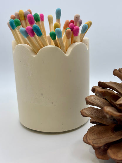 Pot à allumettes artisanal posé sur une table, montrant le grattoir intégré discrètement placé sous le pot