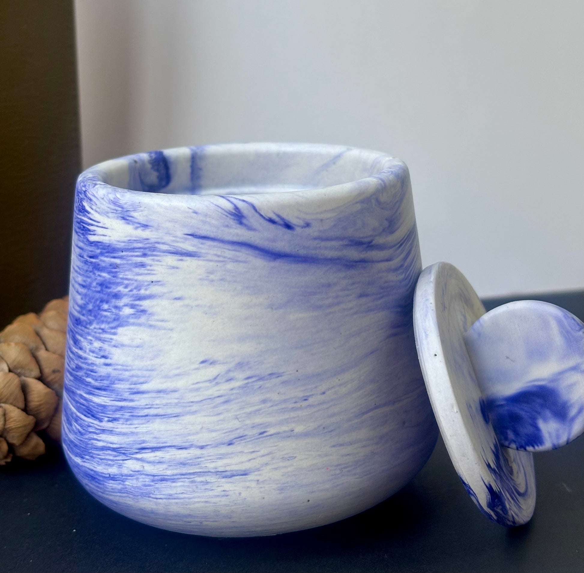 Détail du marbrage bleu et blanc sur pot artisanal en jesmonite